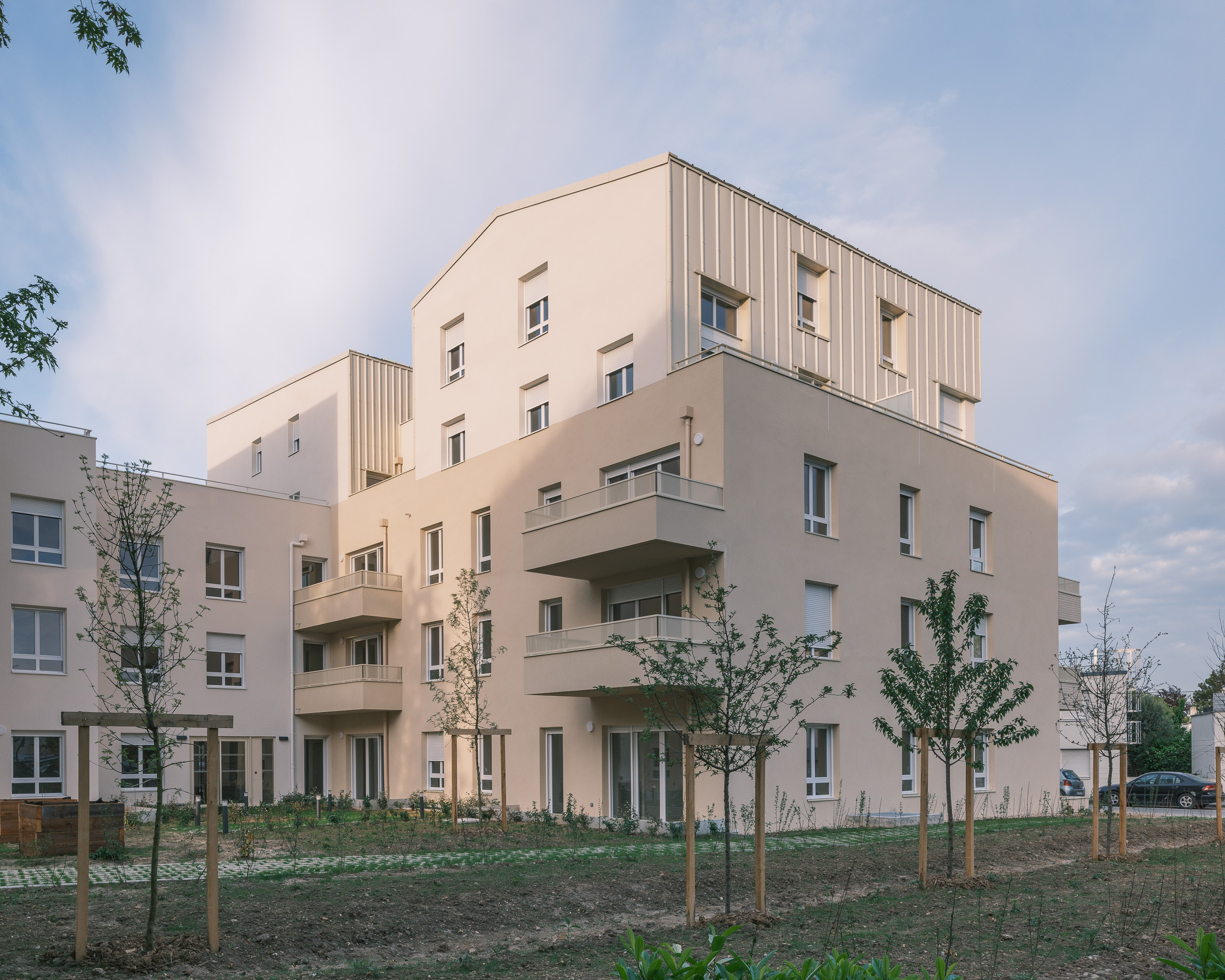 Résidence de logements collectifs sociaux aux Clayes-sous-Bois, composée de bâtiments contemporains avec balcons, jardin paysager et jeunes arbres.